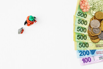 Coins Mountain's over Argentine peso bills with penguins watching it