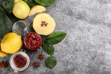 Delicious quince jam and fruits on grey table, flat lay. Space for text