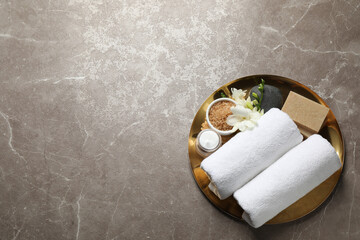 Tray with spa items on grey marble table, top view. Space for text