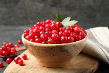 Tasty ripe cranberries on wooden board, closeup