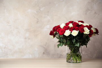 Luxury bouquet of fresh roses on wooden table. Space for text
