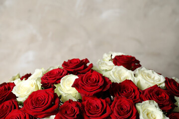 Luxury bouquet of fresh roses on beige background, closeup. Space for text