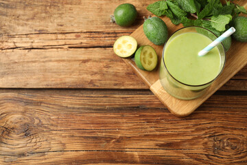 Fototapeta na wymiar Fresh feijoa smoothie and ingredients on wooden table, flat lay. Space for text