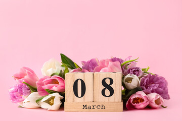 Wooden block calendar with date 8th of March and tulips on pink background, space for text. International Women's Day