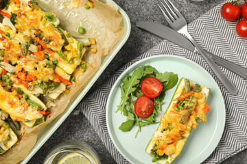 Flat lay composition with baked stuffed zucchinis served on grey table