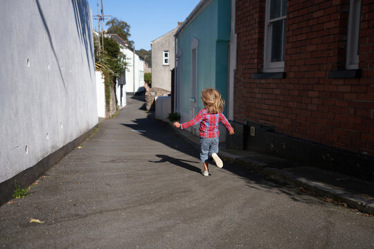 Preschooler running in the street of an old town