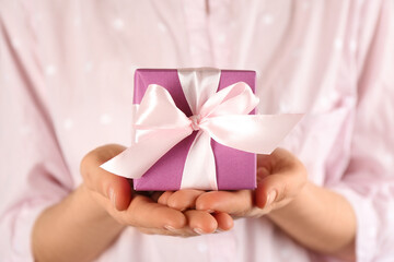 Woman holding gift box, closeup. Valentine's Day celebration