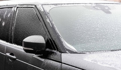 Icy car, ice scraping. Car in ice, winter.