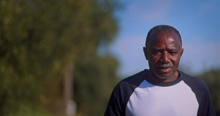 Senior african-american man running outdoors on park - Powered by Adobe
