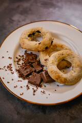 A white plate with gluten-free chocolate donuts and candy bars