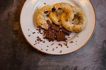 A white plate with gluten-free chocolate donuts and candy bars