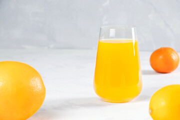 Multifruit juice in glass on white background. Orange juice.Fresh fruits.Healthy food and drink. Vegan food.Lemons and tangerines. Copy sapce. Place for text.Vitamins