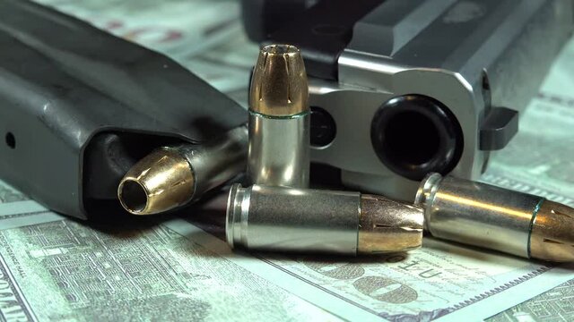 Money Gun and Bullet Ammunition On A Stack Of Money