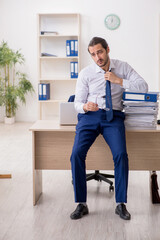 Young businessman unhappy with excessive work in the office