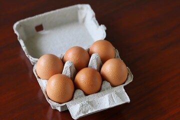 A close up shot of some sweating eggs from the fridge in egg carton.