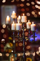 Candlestick with burning candles and bokeh lights in the background