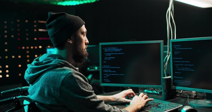 Male hacker using keyboard to type a dangerous malware into bank system. Hacker Breaks into Corporate Data Servers from His Underground Hideout.