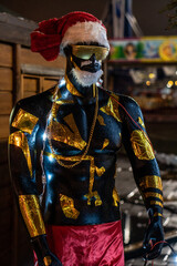 Mannequin of a black man in red hat and santaclaus shorts and gerlands