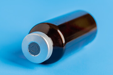 Macro Image Of Amber Vaccine Vial In Blue Background
