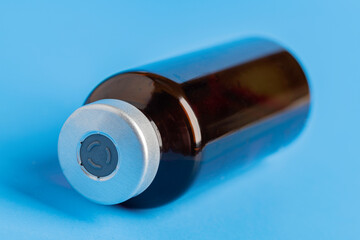 Macro Image Of Amber Vaccine Vial In Blue Background