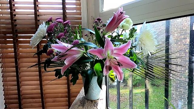 Time lapse of bouquet of white lilies, chrysanths and roses blooming