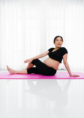 pregnant woman doing yoga exercise in living room at home