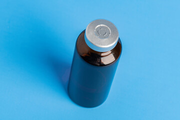 Macro Image Of Amber Vaccine Vial In Blue Background