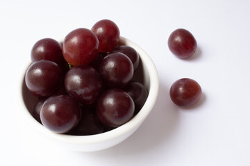 Bowl with grape berries isolated on white background