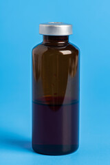 Macro Image Of Amber Vaccine Vial In Blue Background