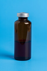 Macro Image Of Amber Vaccine Vial In Blue Background