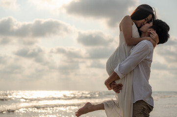 Young couple embracing and kissing on the beach in the sunset.Summer in love,Valentine day concept.