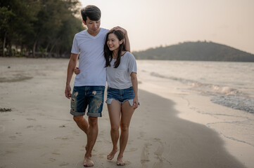 Young couple walking hand in hand with their girlfriend on the beach couple on a summer vacation at the beach.Summer in love,Valentine day concept.