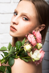 Portrait of a gentle young woman with a beautiful bouquet of rose flowers. Beauty and fashion.