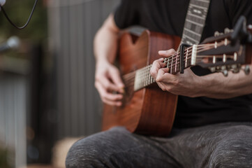 The musicians are checking the sound of the guitar and trying to play the guitar before the event...