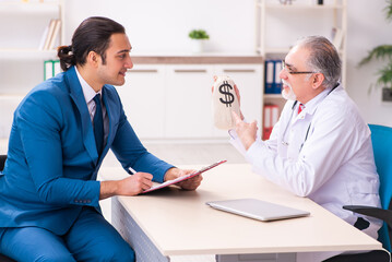 Fototapeta premium Young businessman meeting with old doctor