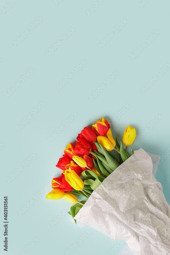 Wall mural Traditional Romantic background with bouquet of red yellow tulips on blue. Top view with copy space, banner, flyer, invitation. Mother's Day, 8 March, Happy Easter background