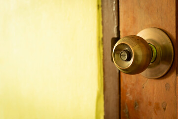 Doorknobs on the wooden door and the cement wall surface in the room.