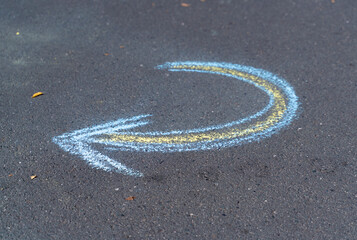 turn around chalk arrow on asphalt with blue and yellow colors