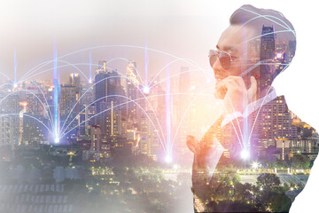 Fototapeta na wymiar Double exposure image of businessman are calling smartphone with wireless communication network over the city.
