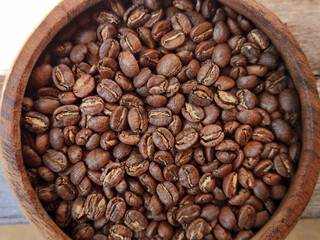 Close up of coffee beans in wooden bowl for background