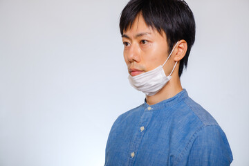 マスクをずらしている男性　あごマスク