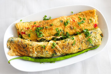 Egg omelette rolled with vegetables on a plate. White Background.