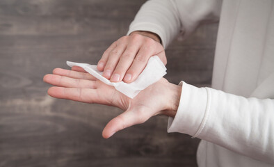 Man cleaning his hand with wet wipe.