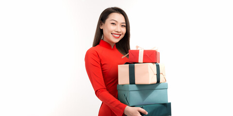 Fototapeta premium Cheerful young lady holding gift boxes in hands and looking at camera with toothy smiles while preparing for Lunar New Year celebration, isolated on white background