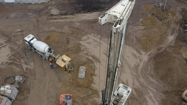 Equipment for installing piles in ground, heavy machines for driving pillars work in laying the foundation building. Construction aerial view height. Construction site drilling pile foundation.