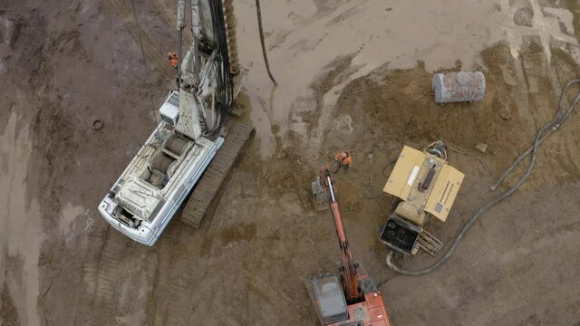 Equipment for installing piles in ground, heavy machines for driving pillars work in laying the foundation building. Construction aerial view height. Construction site drilling pile foundation.