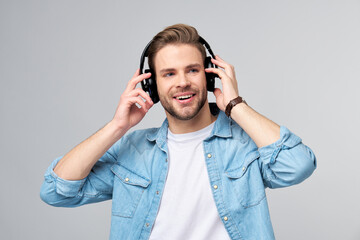 Close up portrait of cheerful young man enjoying listening to music wearing casual jeans outfit
