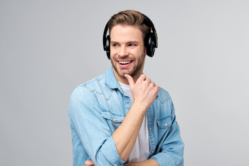 Close up portrait of cheerful young man enjoying listening to music wearing casual jeans outfit