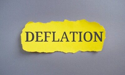 Deflation word written on yellow paper. Concept meaning decrease in the general price level of goods and services.