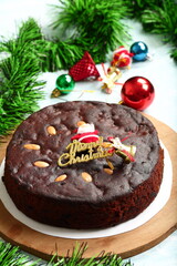 Homemade rich plum Christmas cake with holiday background.